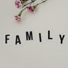 Elegant arrangement of pink flowers and family text on a white background, ideal for family themes.